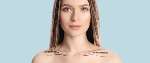 Image of Beautiful young woman with tattoo of wheat spikelets on pale blue background. Banner design