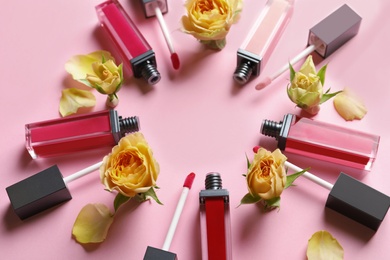 Photo of Composition of lipsticks with flowers on color background