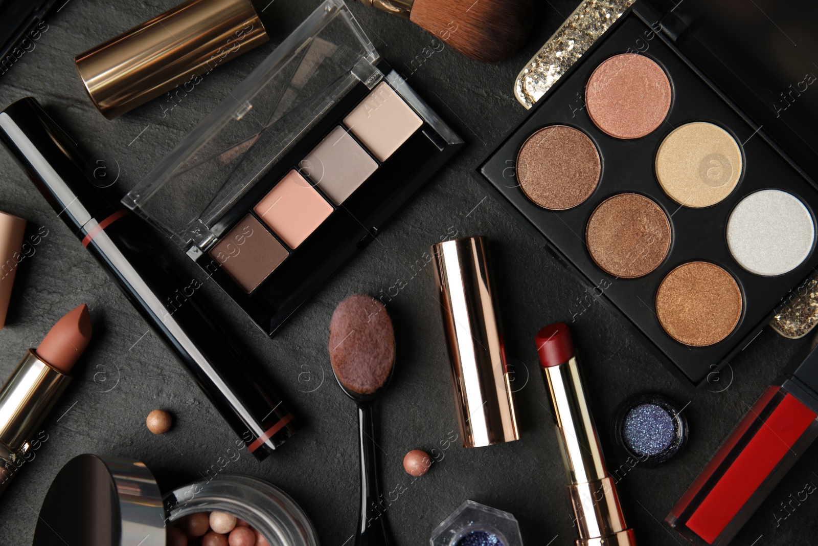 Photo of Flat lay composition with makeup products on black slate table