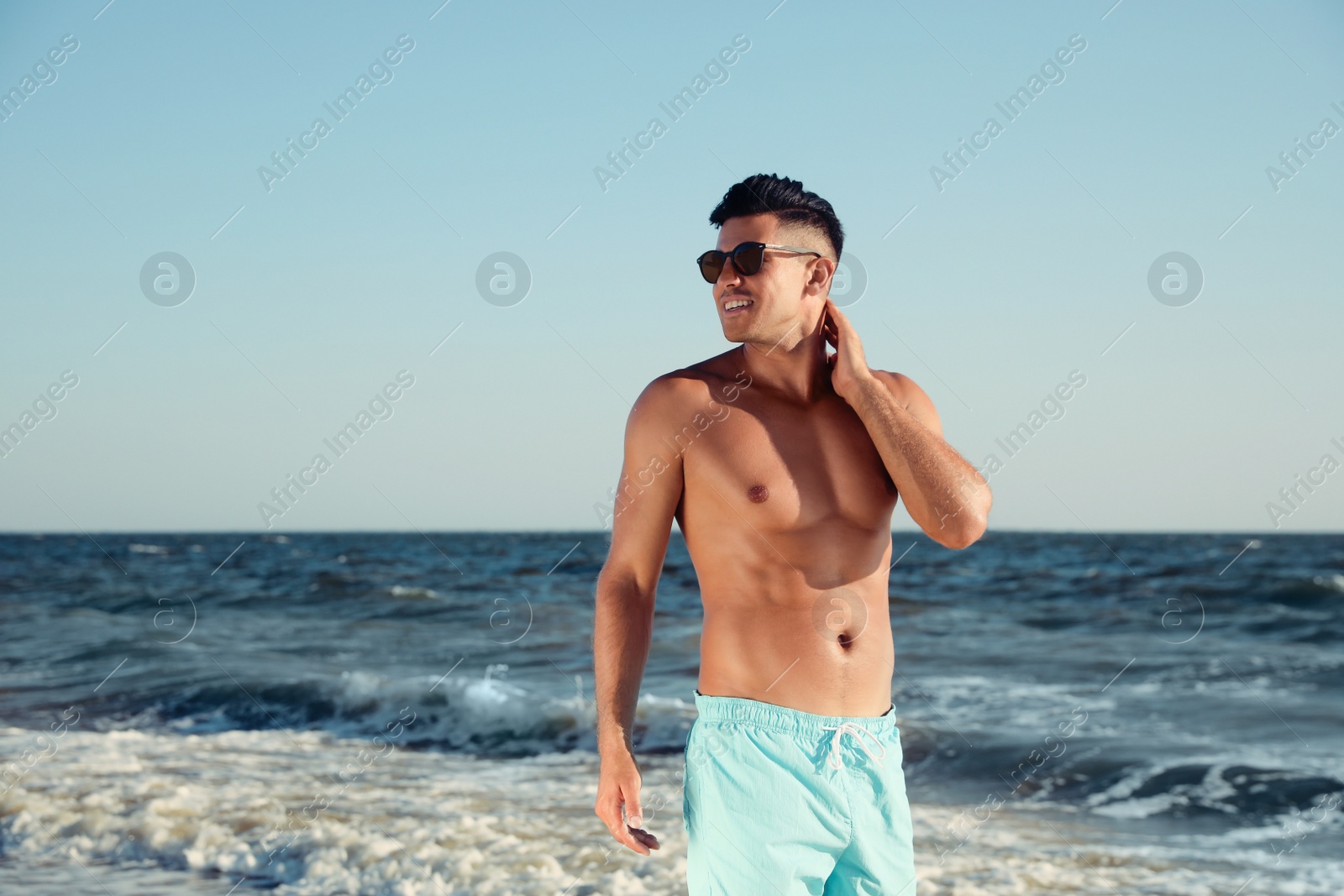 Photo of Handsome man with attractive body on beach