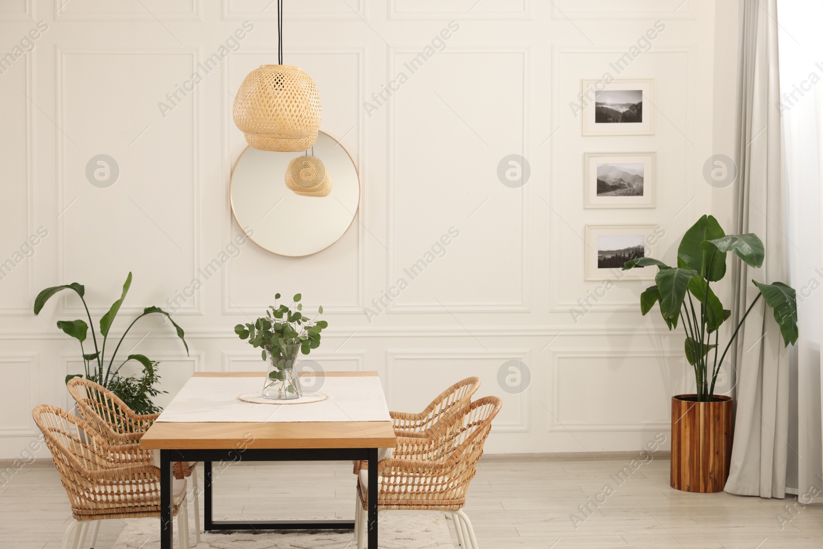 Photo of Stylish dining room with cozy furniture, mirror and plants