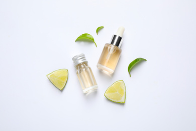 Composition with lime essential oil on white background, top view