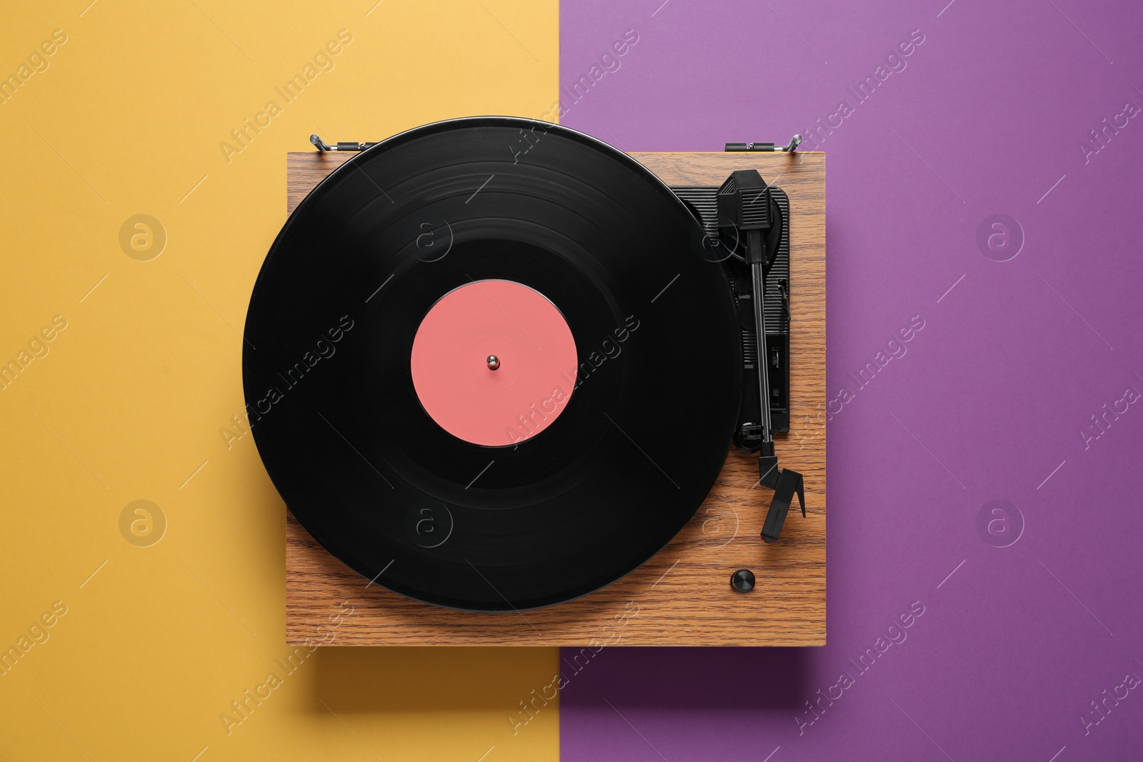 Photo of Modern turntable with vinyl record on color background, top view