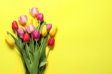 Beautiful colorful tulip flowers on yellow background, flat lay. Space for text