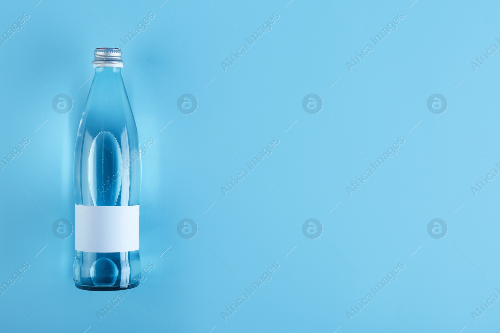 Photo of Bottle of water on color background, top view. Space for text