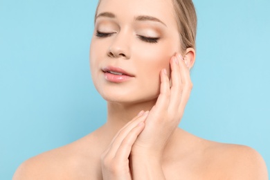 Photo of Portrait of young woman with beautiful face on blue background, closeup