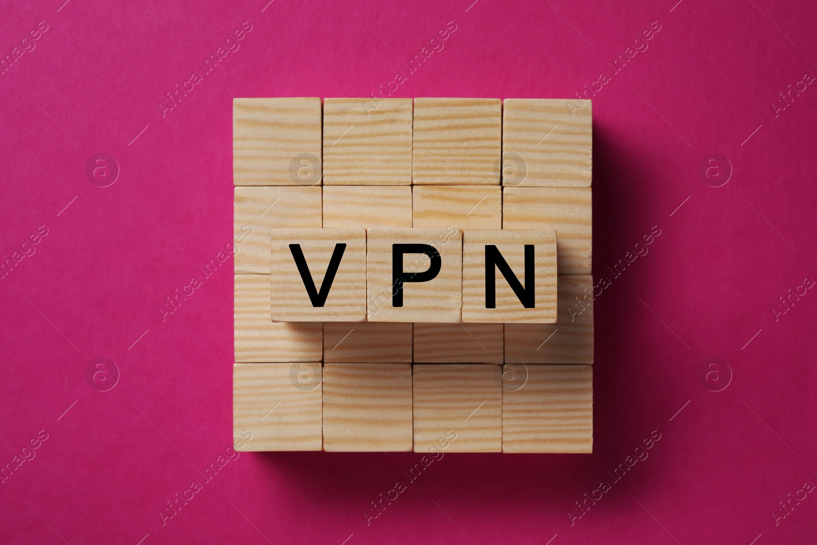 Photo of Wooden cubes with acronym VPN on crimson background, top view