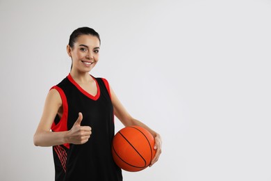 Photo of Basketball player with ball on grey background. Space for text