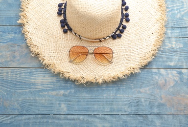 Photo of Stylish hat and sunglasses on wooden background