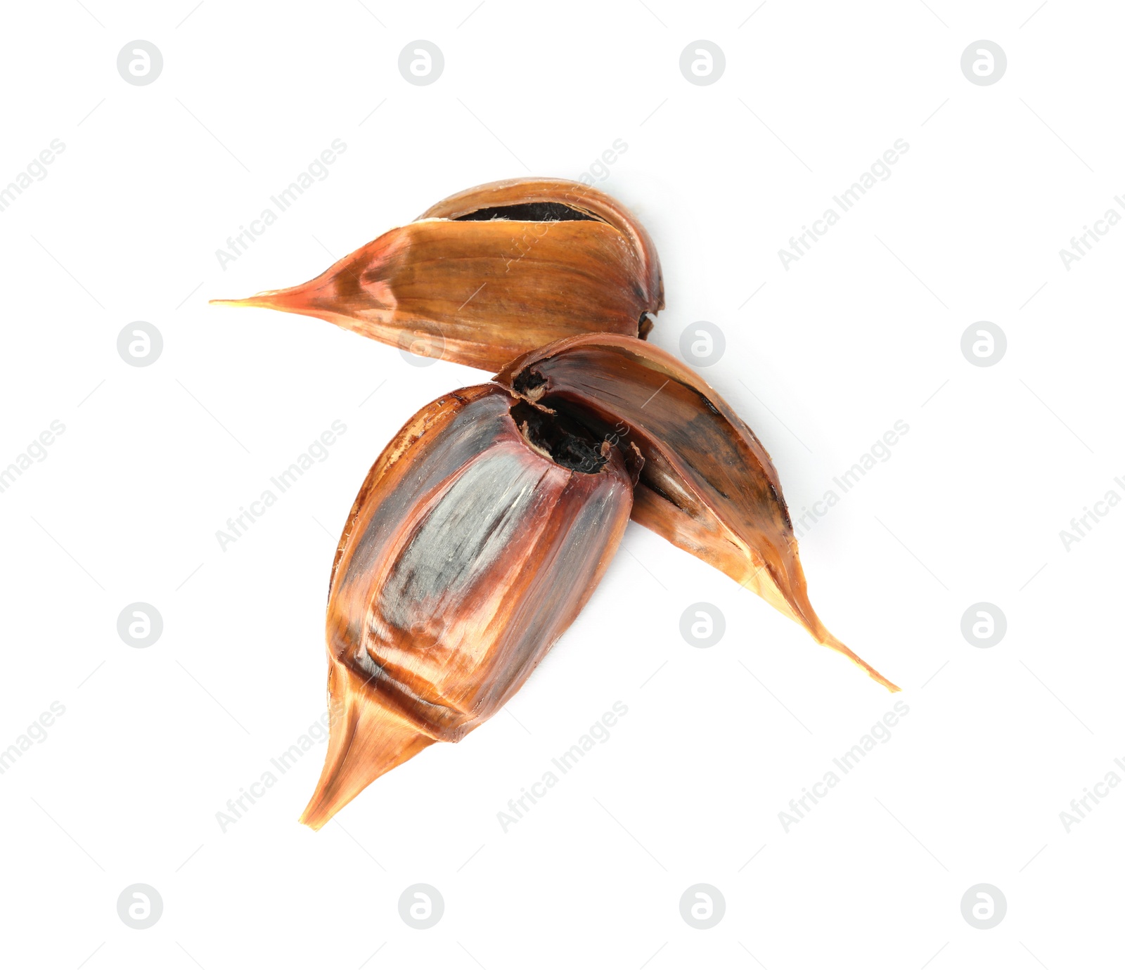 Photo of Unpeeled cloves of aged black garlic on white background, view from above