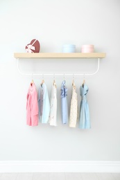 Photo of Rack with different clothes on light wall
