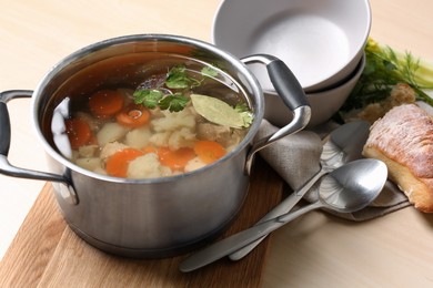 Photo of Delicious vegetable bouillon served on wooden table