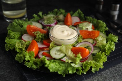 Photo of Plate of delicious vegetable salad with mayonnaise served on table, closeup