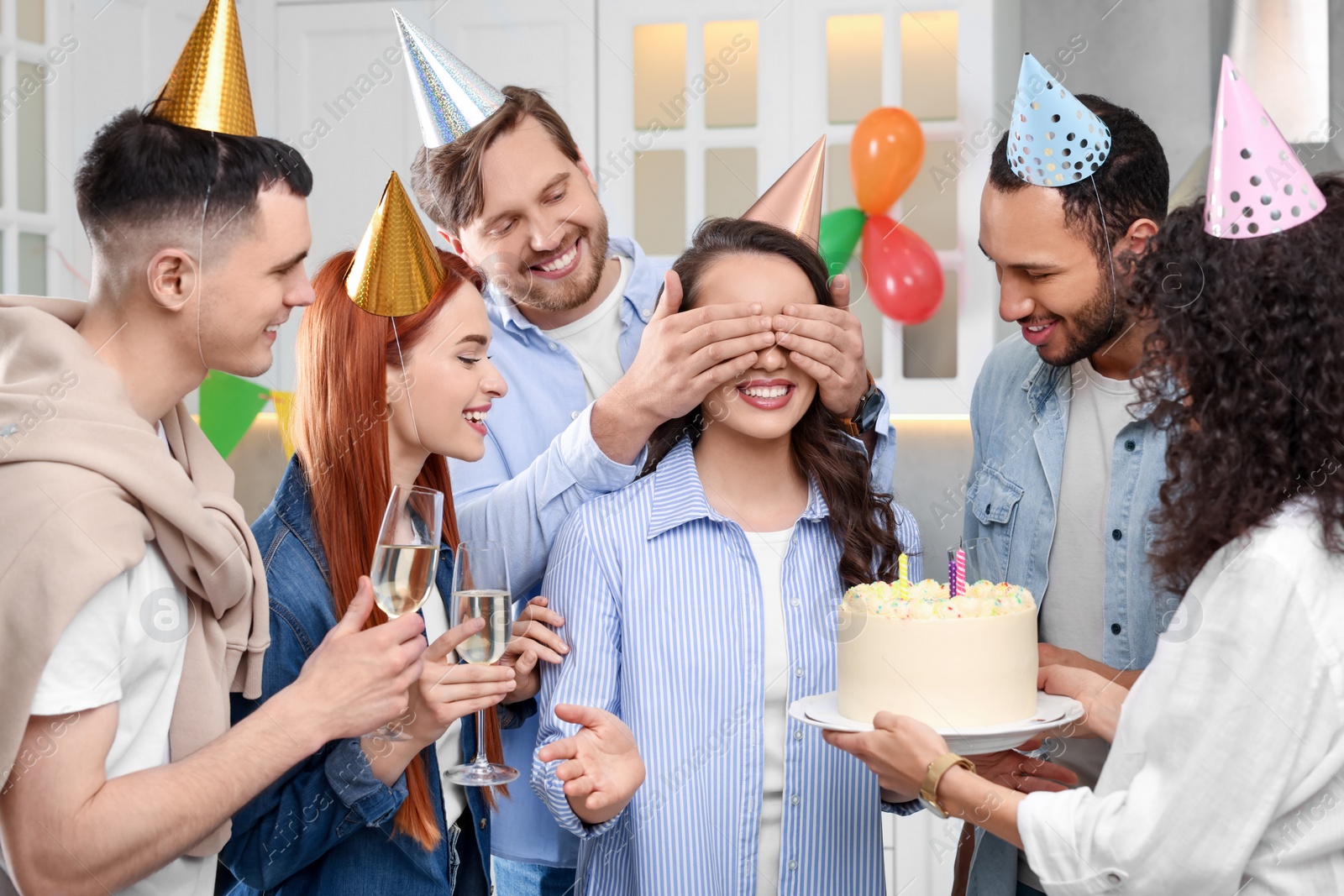 Photo of Happy friends with tasty cake celebrating birthday indoors