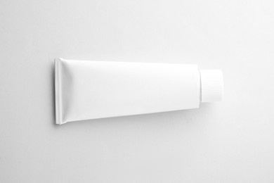 Photo of Blank tube of ointment isolated on white, top view