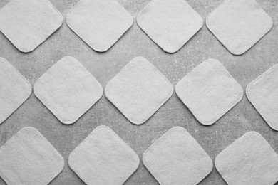 Many clean cotton pads on light grey background, flat lay