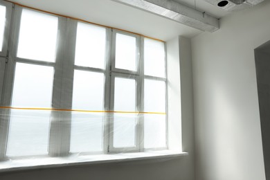 Window and sill covered by plastic film indoors