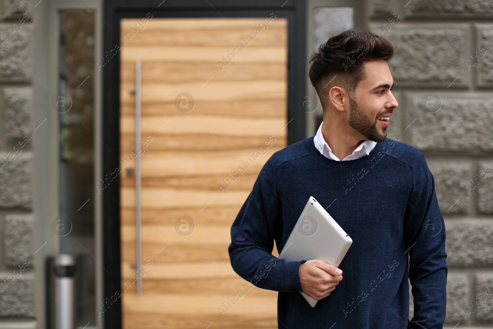 Photo of Young male business owner with tablet near his cafe. Space for text