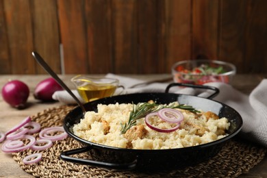 Photo of Delicious chicken risotto served on wooden table