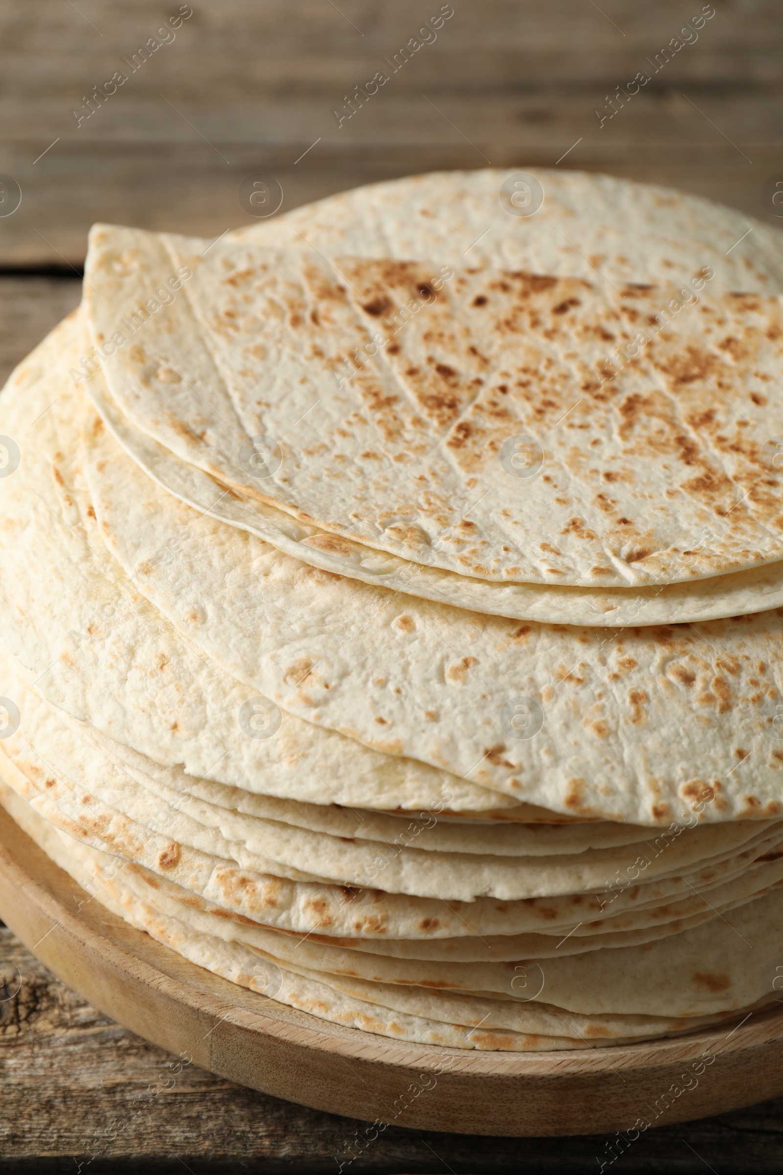 Photo of Stack of tasty homemade tortillas on wooden table