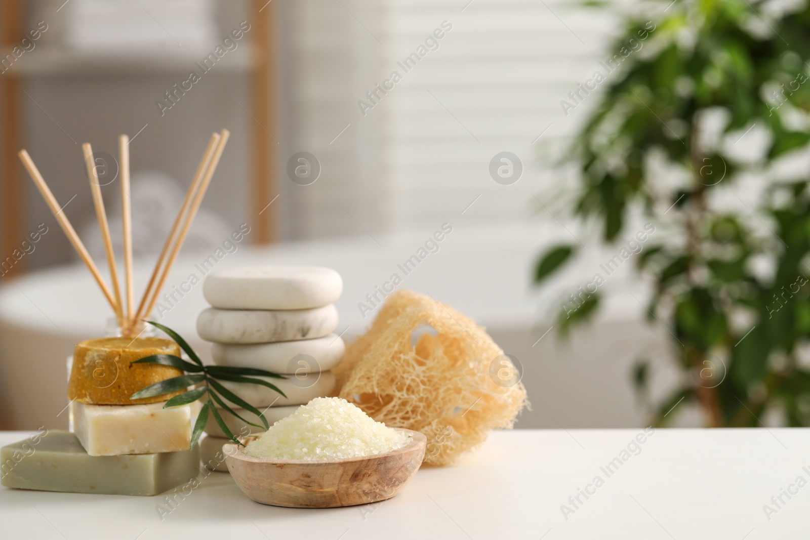 Photo of Composition with different spa products and palm leaves on white table in bathroom, space for text