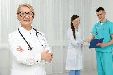 Portrait of doctor near colleagues in clinic