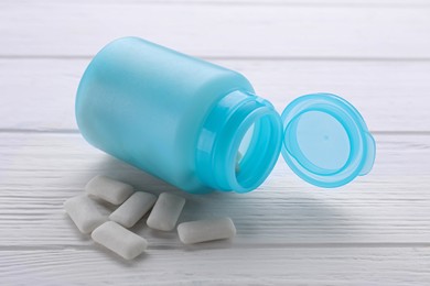 Photo of Jar with chewing gums on white wooden table