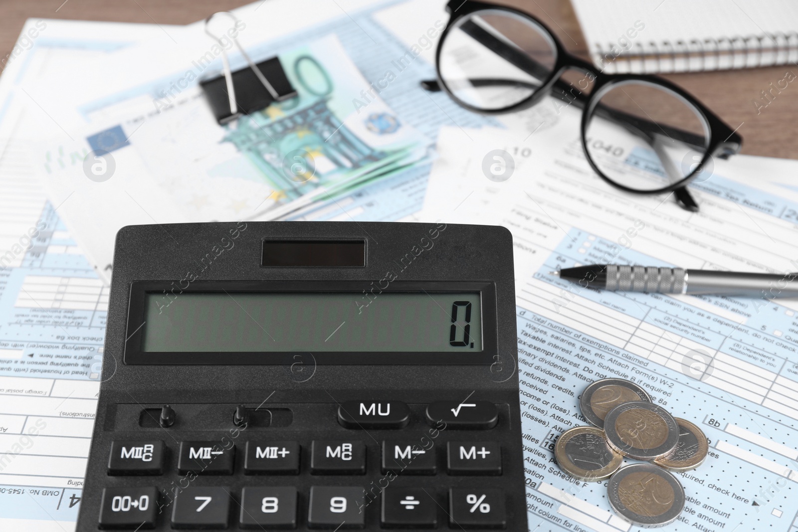 Photo of Tax accounting. Calculator, documents, money, glasses and pen on table, closeup