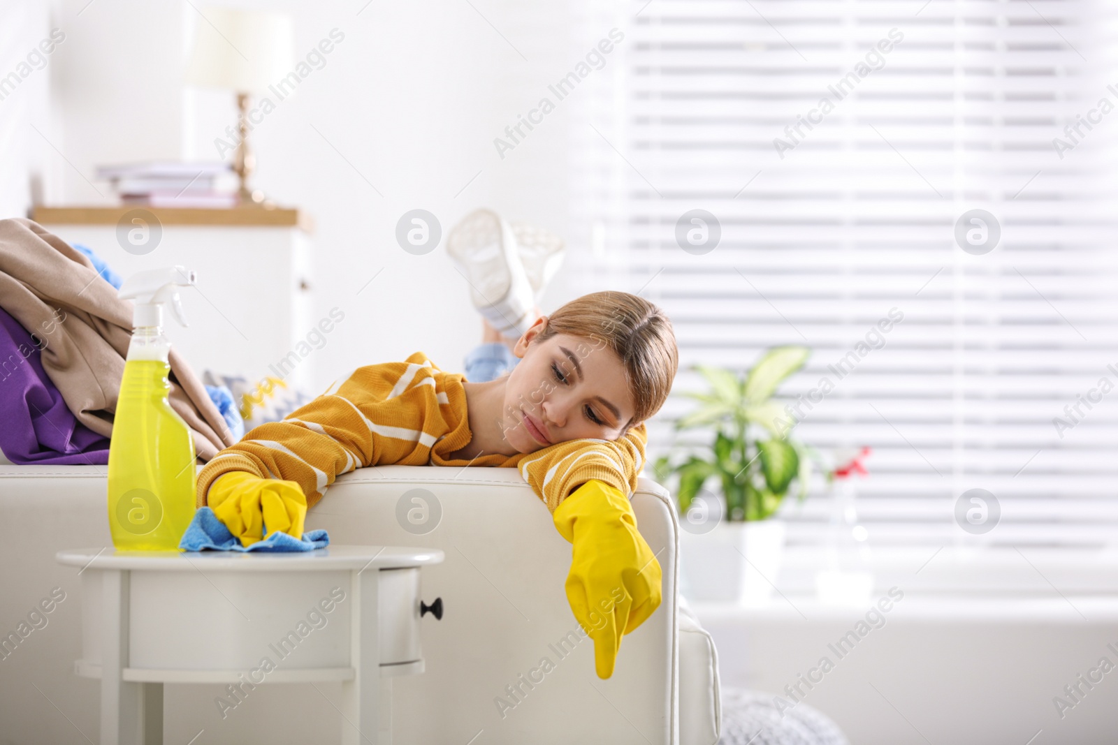 Photo of Lazy young woman wiping table at home. Cleaning and housework