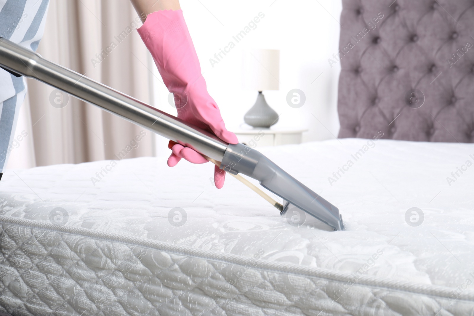 Photo of Woman disinfecting mattress with vacuum cleaner, closeup. Space for text