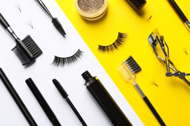 Photo of Flat lay composition with false eyelashes and other makeup products on color background