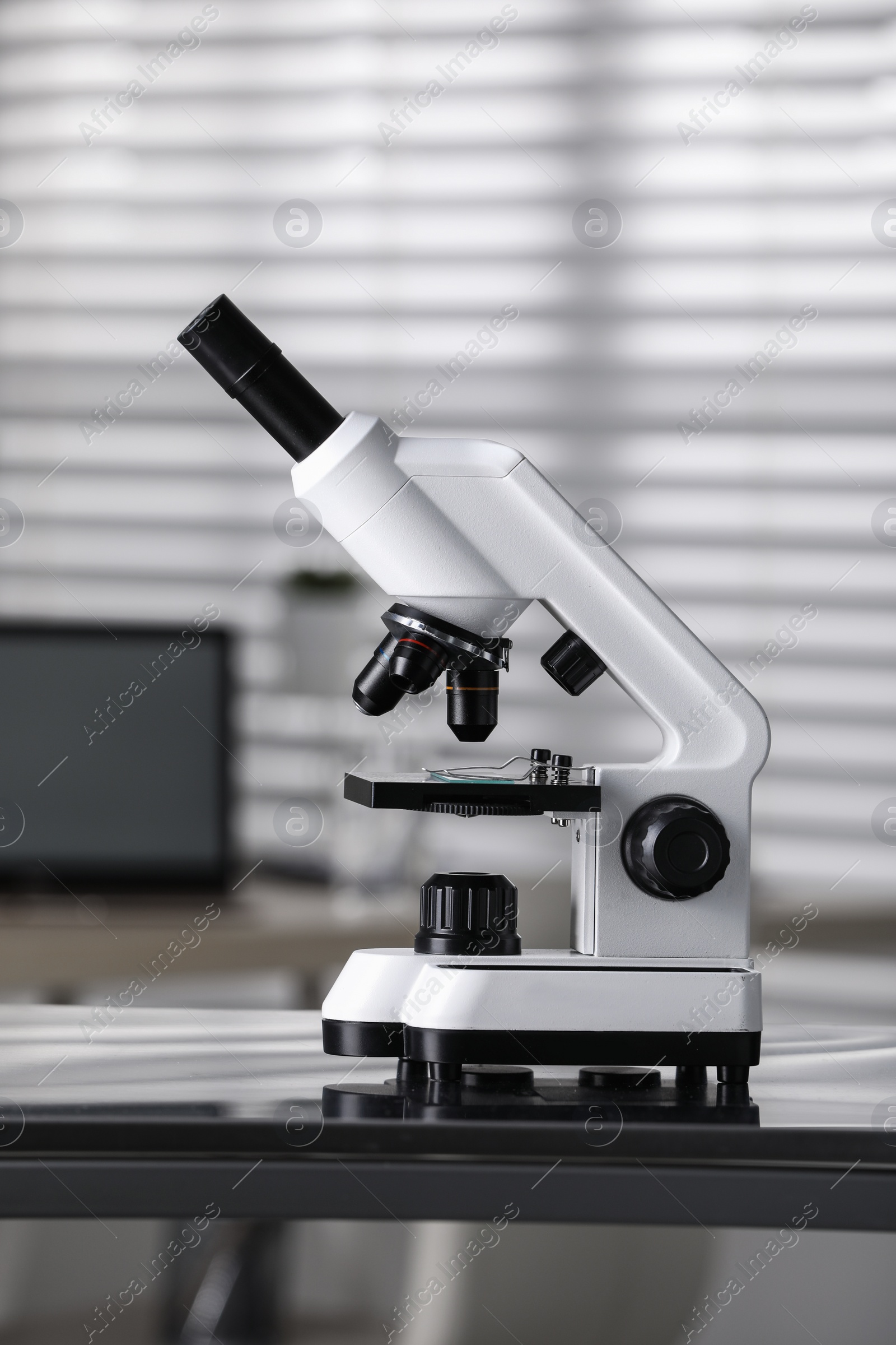 Photo of Modern medical microscope on metal table in laboratory