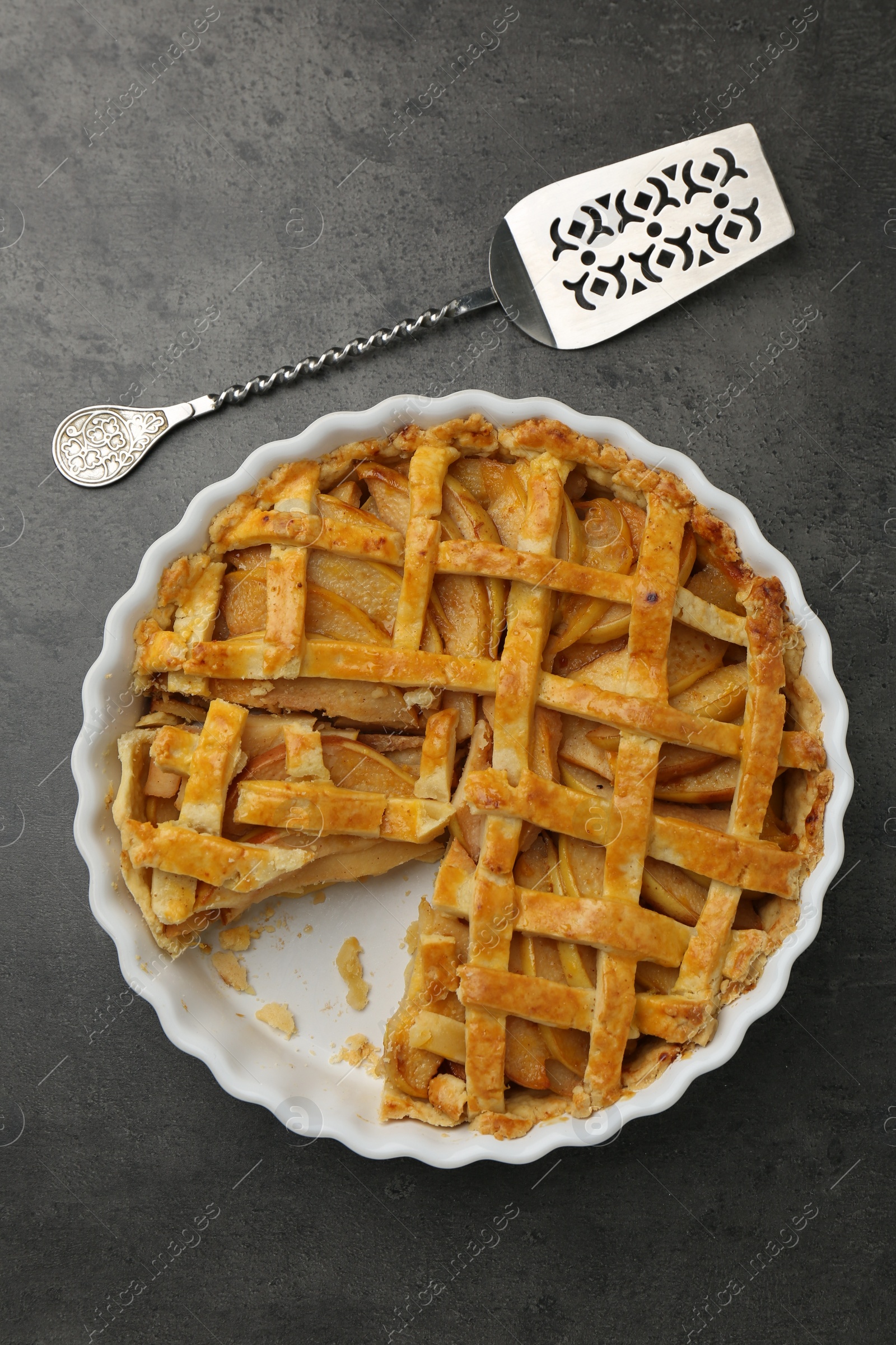 Photo of Tasty homemade quince pie with cake server on grey table, flat lay