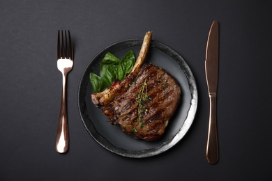 Flat lay composition with grilled meat steak on black background