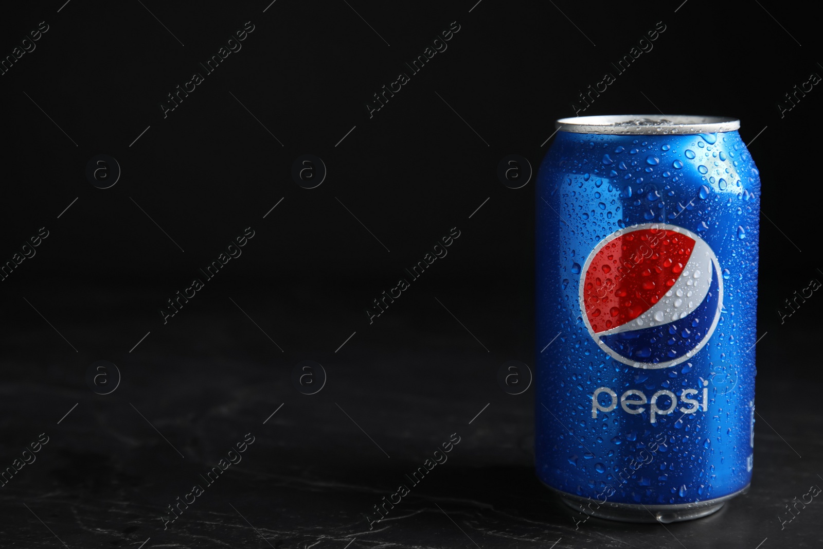 Photo of MYKOLAIV, UKRAINE - FEBRUARY 08, 2021: Can of Pepsi with water drops on black table, space for text