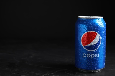 Photo of MYKOLAIV, UKRAINE - FEBRUARY 08, 2021: Can of Pepsi with water drops on black table, space for text