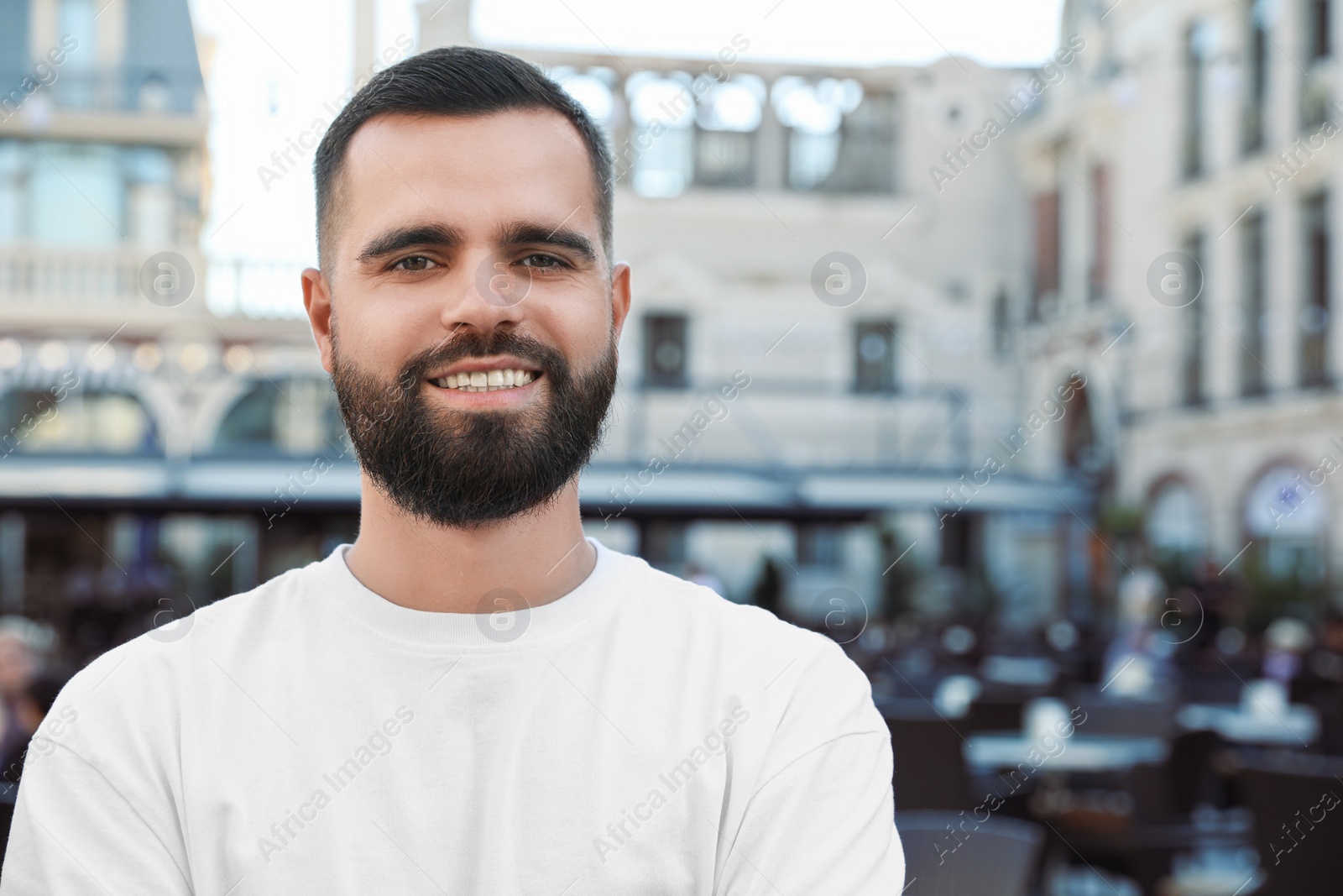 Photo of Portrait of happy handsome man on city street. Space for text