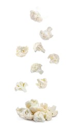 Many fresh cauliflower florets falling into pile on white background