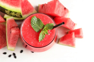 Summer watermelon drink in glass and sliced fresh fruit on table, top view