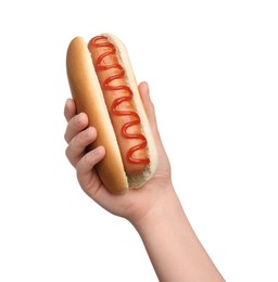 Woman holding delicious hot dog with ketchup on white background, closeup