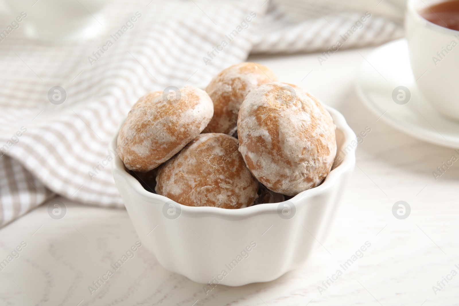 Photo of Tasty homemade gingerbread cookies in bowl on white wooden table