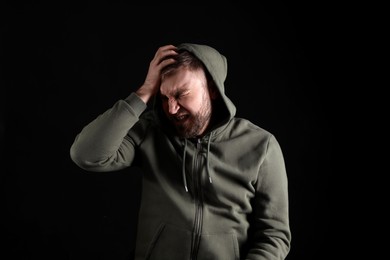 Photo of Portrait of emotional young man on black background. Personality concept