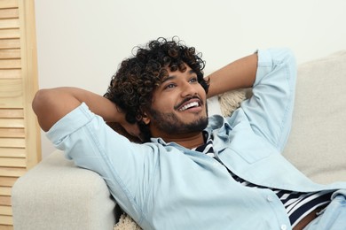 Photo of Portrait of handsome smiling man on sofa indoors