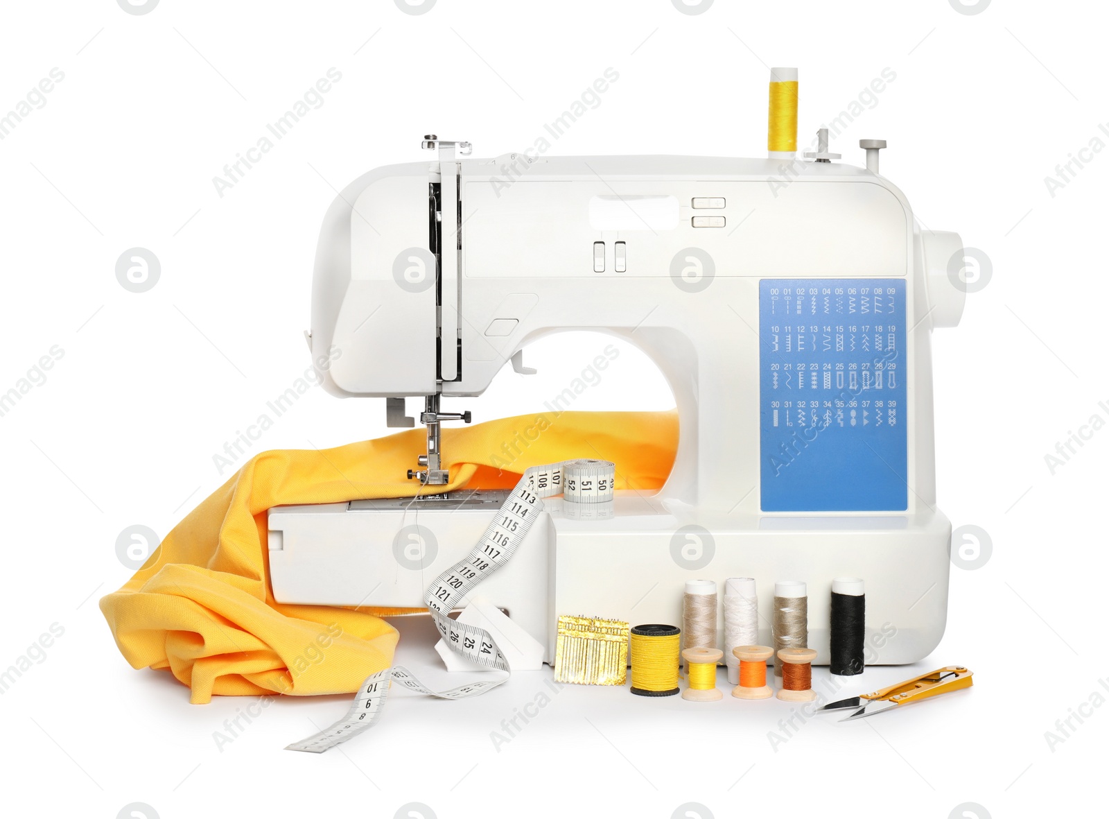 Photo of Modern sewing machine with yellow cloth and craft accessories isolated on white