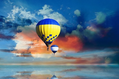 Image of Fantastic dreams. Hot air balloons in blue sky with clouds over sea