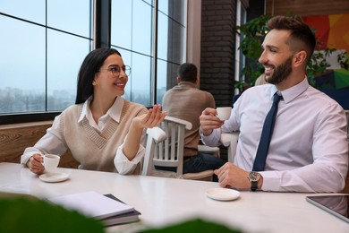 Coworkers talking in cafe during coffee break