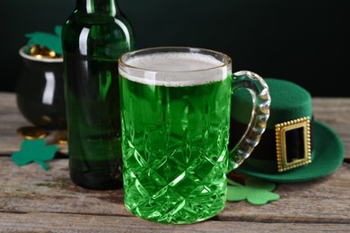Photo of St. Patrick's day party. Green beer, leprechaun hat, pot of gold and decorative clover leaves on wooden table