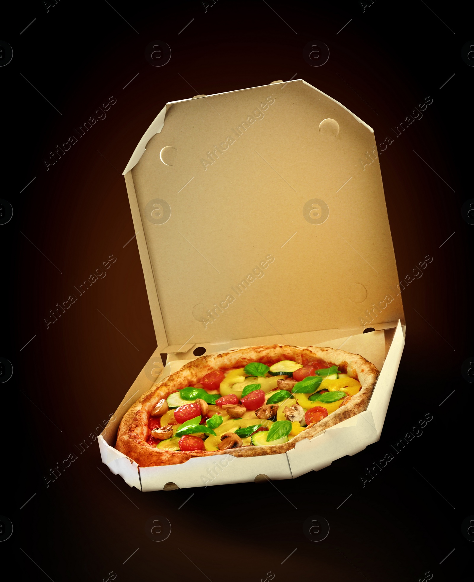 Image of Hot tasty vegetable pizza in cardboard box on dark background. Image for menu or poster