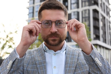 Photo of Portrait of handsome bearded man in glasses outdoors