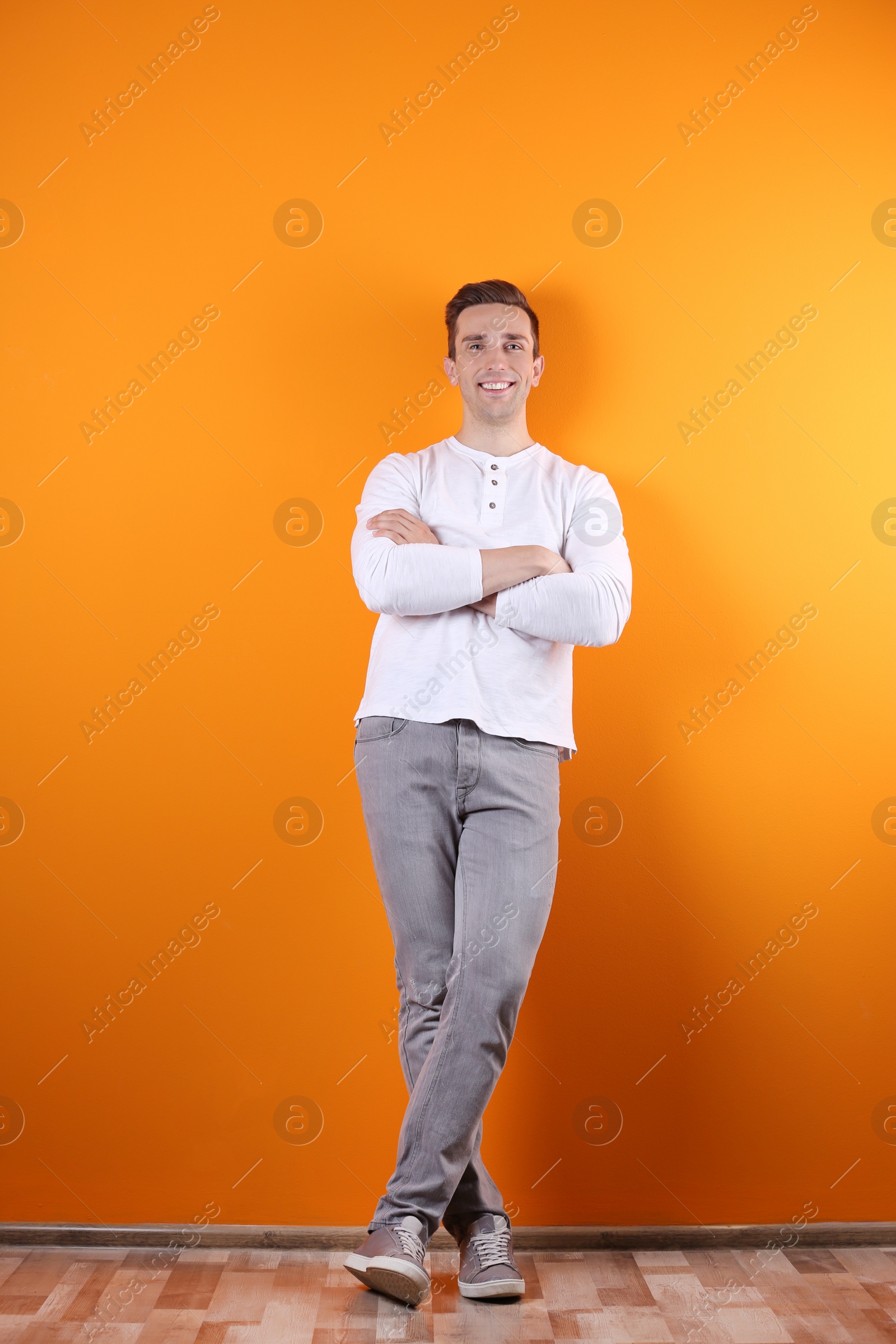 Photo of Handsome young man smiling on color background